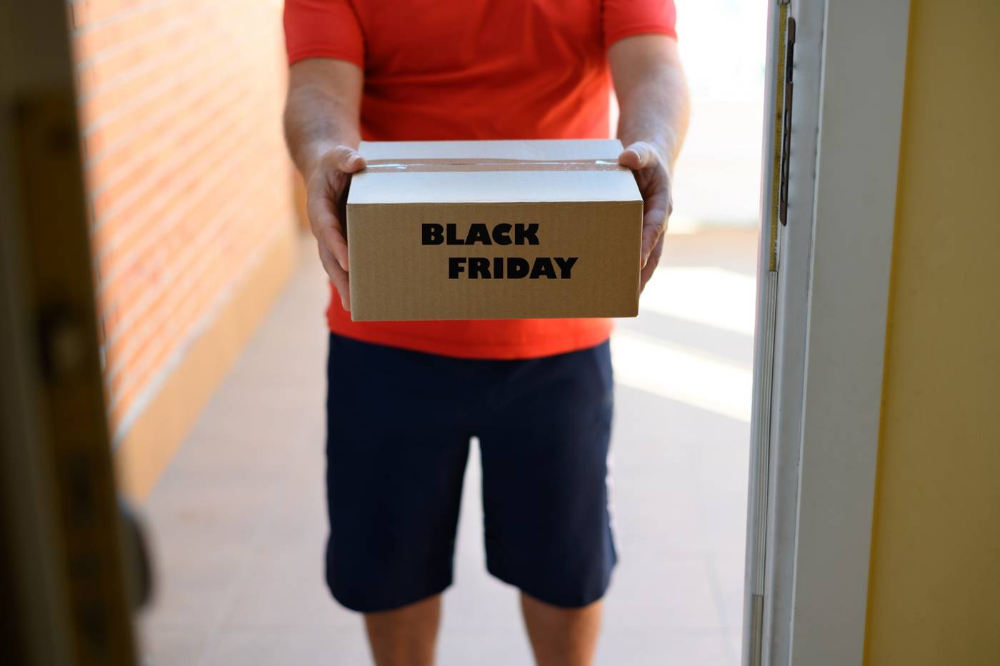 Bud afleverer en pakke mærket Black Friday ved hoveddøren