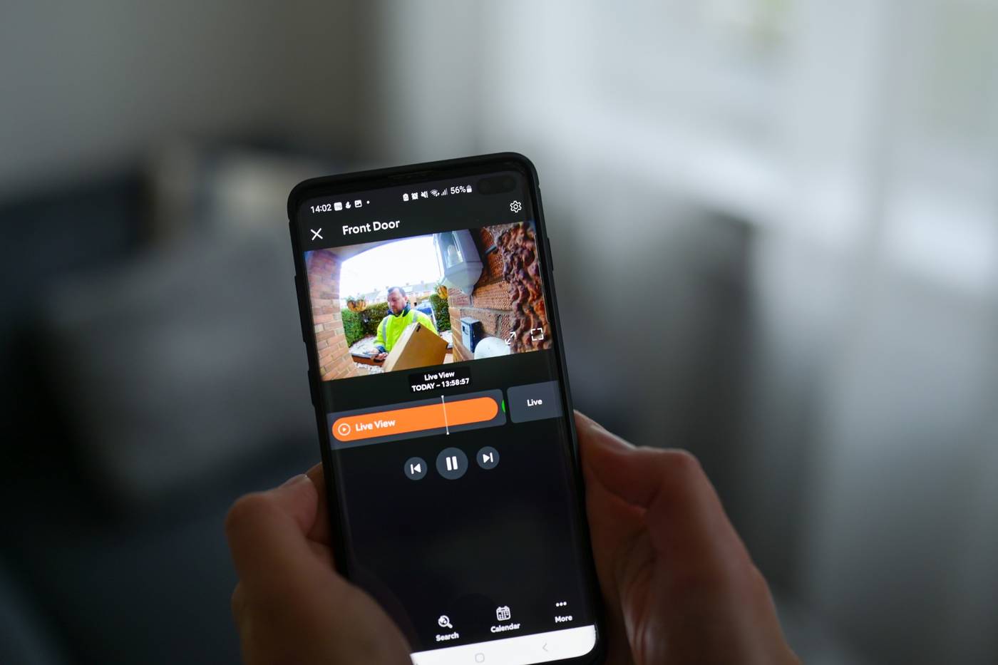 Mobil viser live-billede fra en ringeklokke med kamera, hvor et bud står med en pakke ved hoveddøren